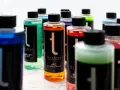 Flera flaskor med färgglada bilvårdsprodukter, inklusive en sprayflaska för kemikalier.