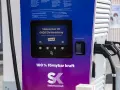 OKQ8 electric car charging station with two charging cables and a screen displaying "Welcome to OKQ8 Electric Charging".