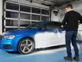Man skummar en blå bil med Autoglym Polar Blast.