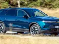 Blå Opel Grandland kör på en grusväg, kanske med ett litet **opel grandland problem** med dammet som virvlar upp.