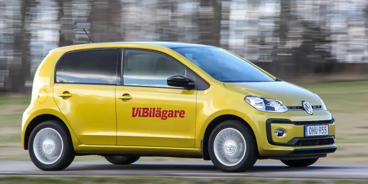 Gul Volkswagen up! kör på en väg. Texten "ViBilägare" syns på sidan. Ett potentiellt vw up problem kan vara dess lilla storlek.