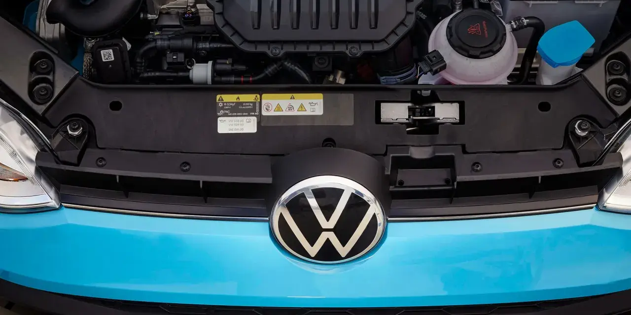 Motorutrymmet på en blå Volkswagen. En etikett visar information om oljespecifikationer, vilket kan vara relevant vid ett volkswagen gasbil problem.