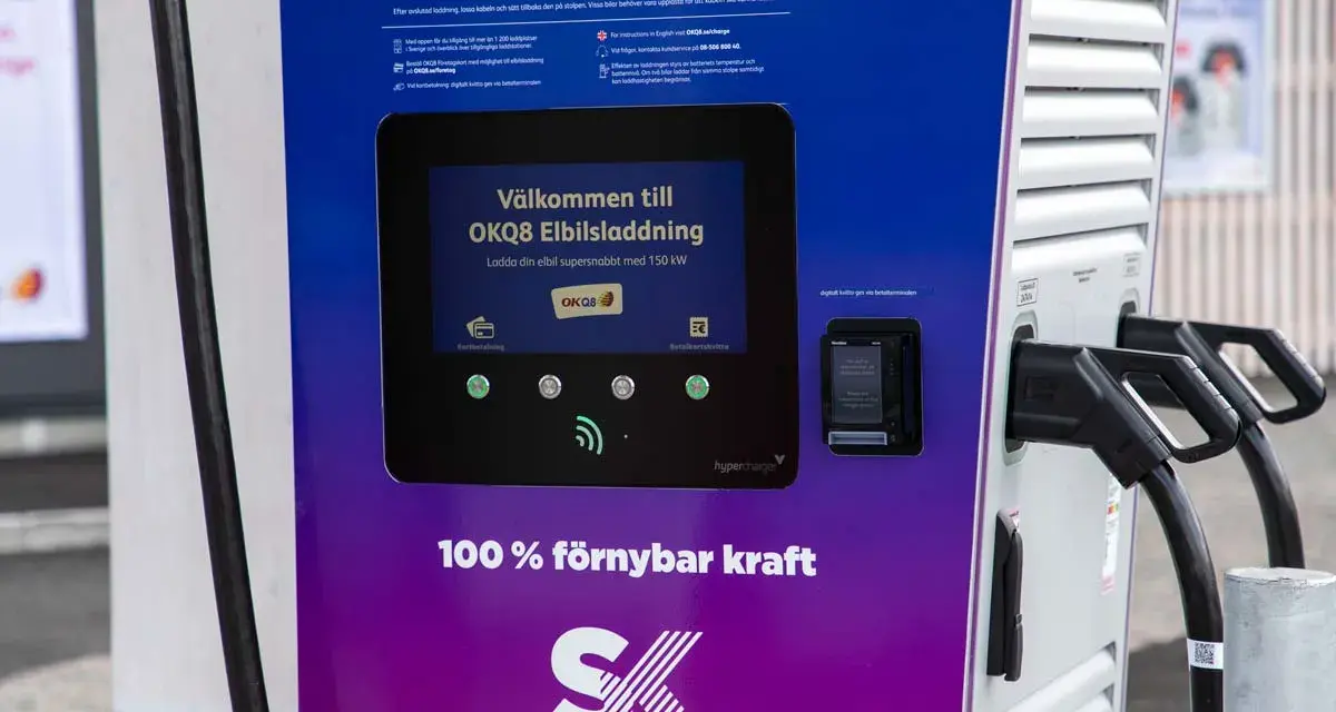OKQ8 electric car charging station with two charging cables and a screen displaying "Welcome to OKQ8 Electric Charging".