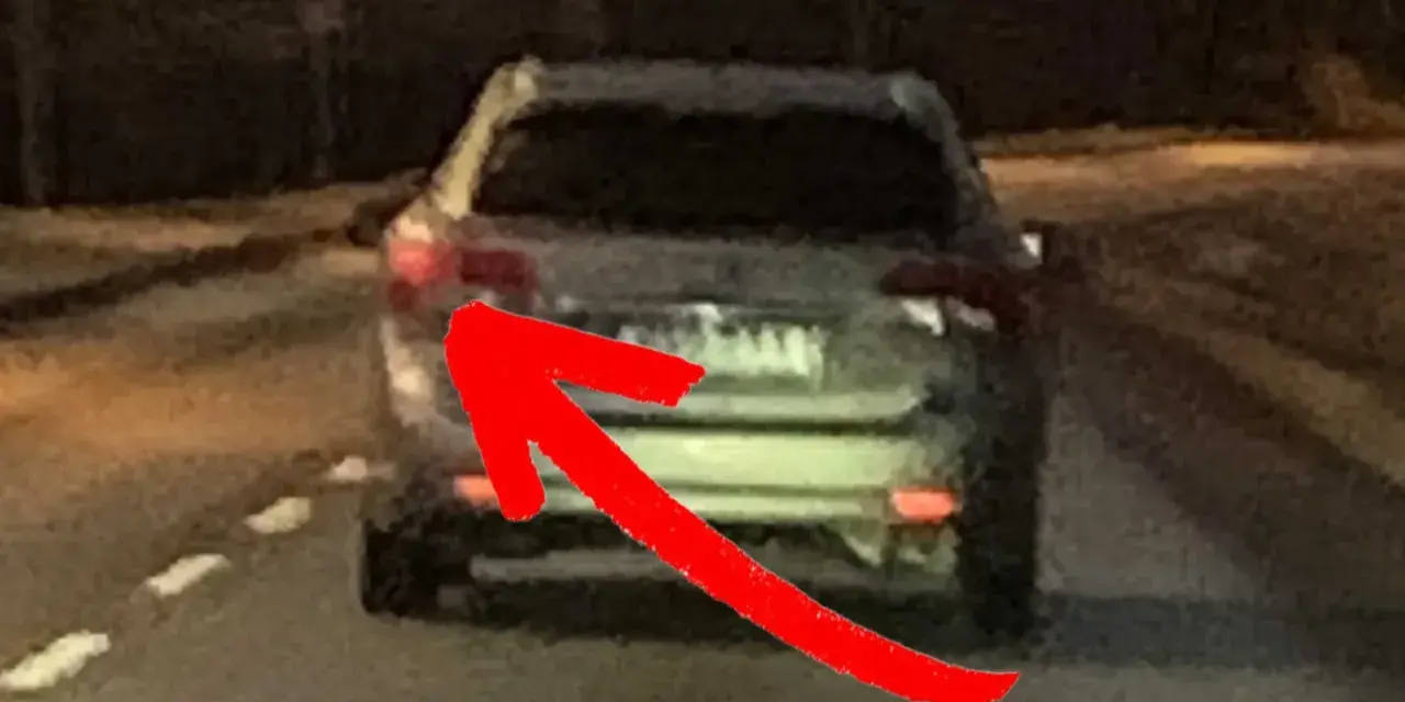En röd pil pekar på bakljuset på en bil. Det är mörkt ute, och man undrar om man måste ha bakljus på dagen.
