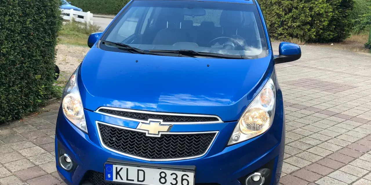 Blå Chevrolet Spark med registreringsskylten KLD 836. Ett potentiellt chevrolet spark problem kan vara att den inte startar.