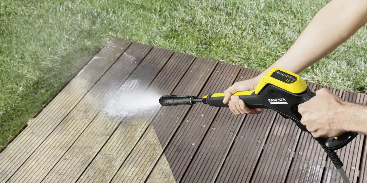 En person använder en Kärcher K4 Power Control för att rengöra en träaltan.