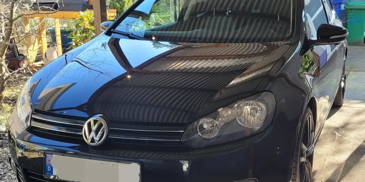 Svart VW Golf med en potentiell vw dsg problem. Bilen står parkerad utomhus under ett skärmtak.