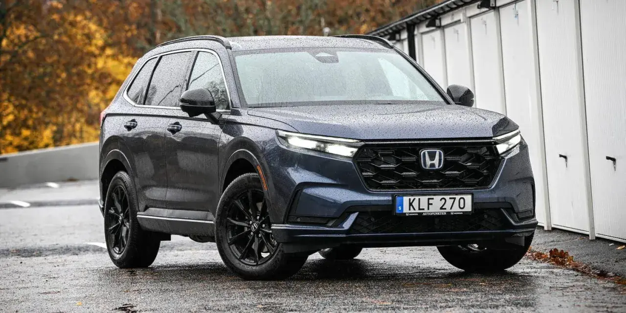 Mörkblå Honda CR-V med svarta fälgar står på en regnvåt asfaltsväg. En potentiell honda cr-v problem kan vara att den drar till sig regn.