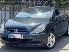Svart Peugeot 307 CC cabriolet, taket nere. Solen reflekteras i lacken, kanske ett tecken på ett kommande problem?