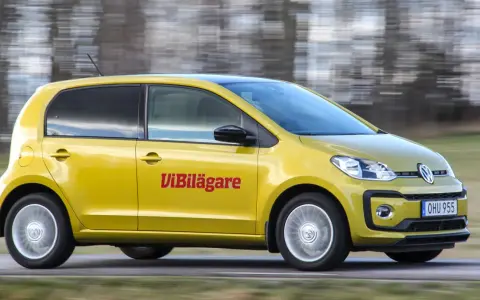 Gul Volkswagen up! kör på en väg. Texten "ViBilägare" syns på sidan. Ett potentiellt vw up problem kan vara dess lilla storlek.