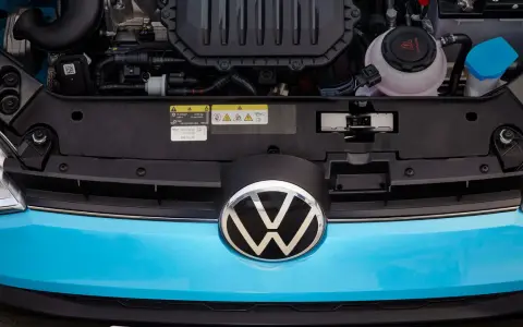 Motorutrymmet på en blå Volkswagen. En etikett visar information om oljespecifikationer, vilket kan vara relevant vid ett volkswagen gasbil problem.