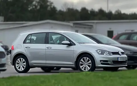 Silver Volkswagen Golf, redo kamremsbyte för att säkerställa optimal prestanda. Bilen står parkerad utomhus.
