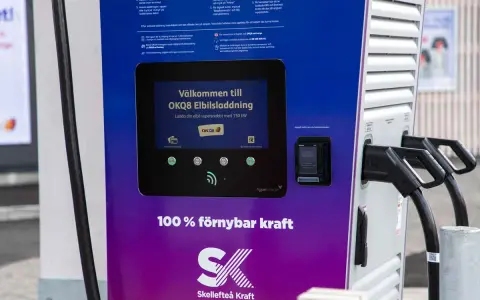 OKQ8 electric car charging station with two charging cables and a screen displaying "Welcome to OKQ8 Electric Charging".