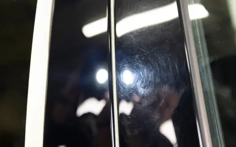 Två svarta ytor bredvid varandra. Den vänstra är blank och reflekterande, den högra har en djup repa i lacken som syns som virvlar.