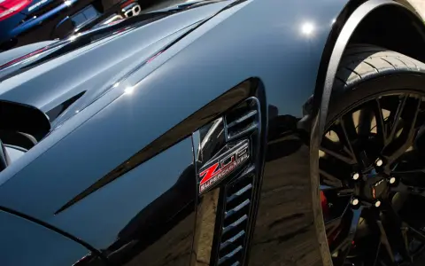 Svart Corvette med "Z06 SUPERCHARGED"-emblem. Lacken är så blank att den nästan ser ut som en keramisk detaljer.
