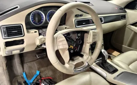 Interiör av en Volvo S80 där instrumentpanelen är demonterad, troligen på grund av ett volvo s80 problem. Ratt och mittkonsol syns.