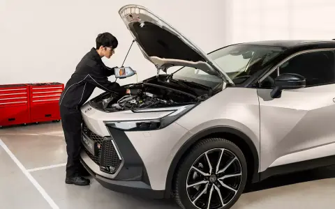 Mekaniker fyller på olja i en Toyota C-HR. För bästa service och pris på din Toyota Yaris, besök oss.
