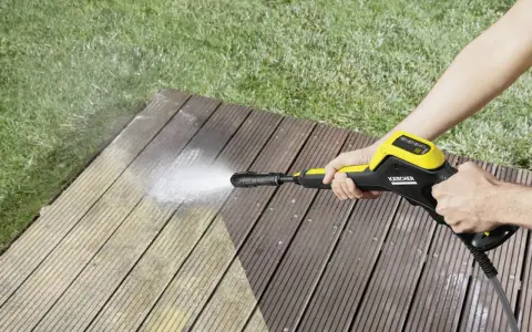 En person använder en Kärcher K4 Power Control för att rengöra en träaltan.