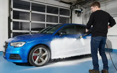 Man skummar en blå bil med Autoglym Polar Blast.