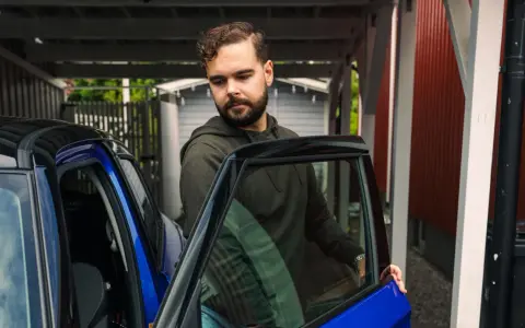 Man öppnar dörren till en blå bil. För att bilen ska hålla sig i gott skick måste man serva bilen varje år.