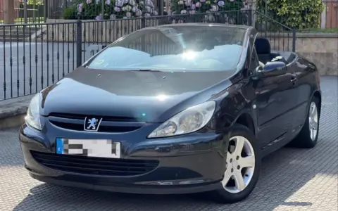 Svart Peugeot 307 CC cabriolet, taket nere. Solen reflekteras i lacken, kanske ett tecken på ett kommande problem?