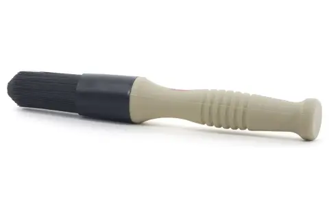 En borste med beige handtag och svart borsthuvud, perfekt för att applicera lahega polermedel för en skinande finish.