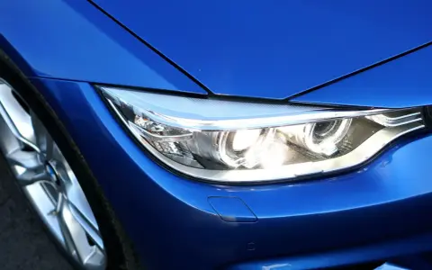 Blå BMW-strålkastare, redo för en prewash. Fälgen syns till vänster.