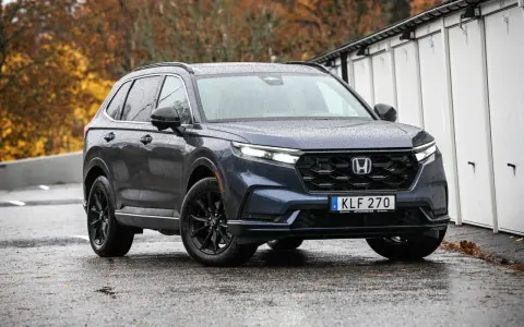 Mörkblå Honda CR-V med svarta fälgar står på en regnvåt asfaltsväg. En potentiell honda cr-v problem kan vara att den drar till sig regn.