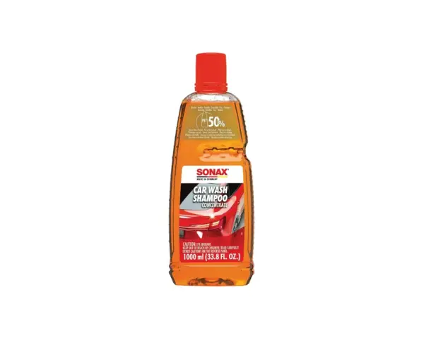 En flaska Sonax Car Wash Shampoo Concentrate, en orange vätska med röd kork. Perfekt för att skapa mycket skum vid biltvätt.