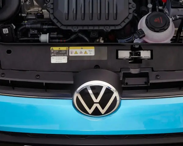 Motorutrymmet på en blå Volkswagen. En etikett visar information om oljespecifikationer, vilket kan vara relevant vid ett volkswagen gasbil problem.
