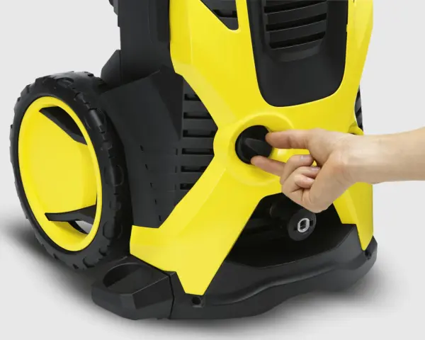 En hand vrider på reglaget på en gul och svart högtryckstvätt, liknande den du hittar till bra kärcher k5 prisjakt.