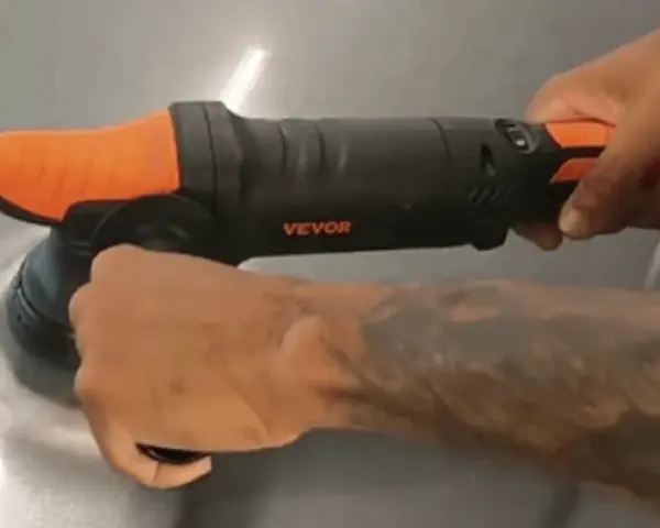 En person använder en polermaskin med borrmaskin för att polera en yta.