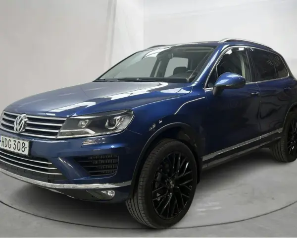 Blå VW Touareg med svarta fälgar. En bil med ett potentiellt vw touareg problem, står på en snurrplatta i en studio.