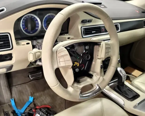 Interiör av en Volvo S80 där instrumentpanelen är demonterad, troligen på grund av ett volvo s80 problem. Ratt och mittkonsol syns.