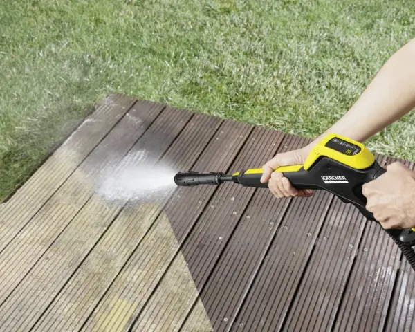 En person använder en Kärcher K4 Power Control för att rengöra en träaltan.