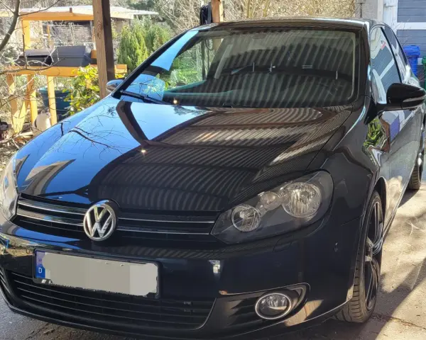 Svart VW Golf med en potentiell vw dsg problem. Bilen står parkerad utomhus under ett skärmtak.