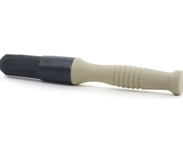 En borste med beige handtag och svart borsthuvud, perfekt för att applicera lahega polermedel för en skinande finish.