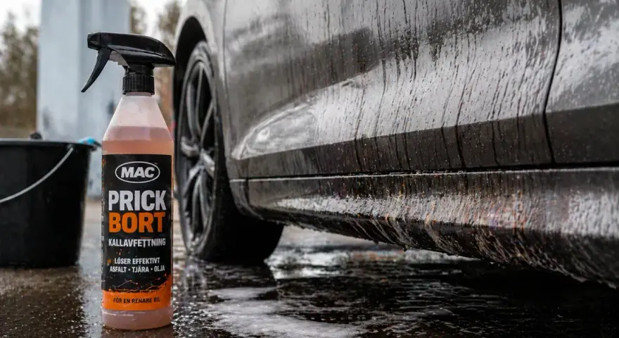 En flaska med MAC Prick Bort kallavfettning står bredvid en smutsig bil. Denna produkt är perfekt för att få bort asfalt, tjära och olja, vilket ger en renare bil.