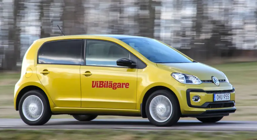 Gul Volkswagen up! kör på en väg. Texten "ViBilägare" syns på sidan. Ett potentiellt vw up problem kan vara dess lilla storlek.