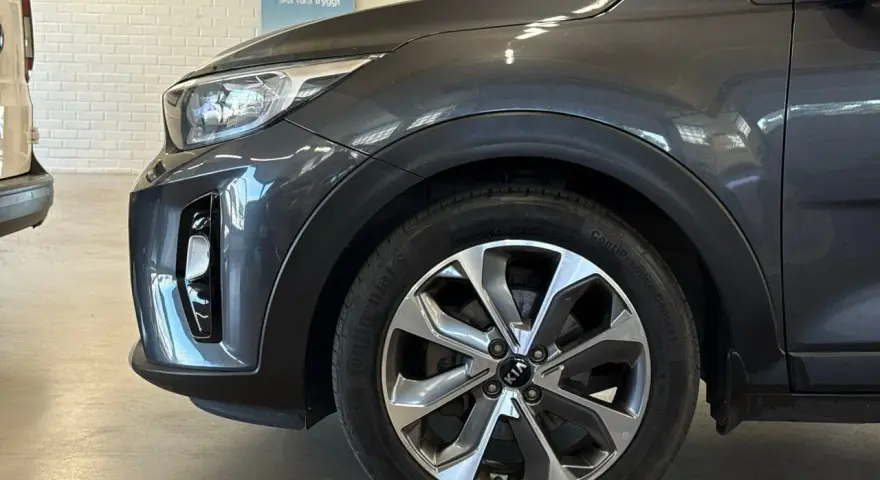 Grå Kia Stonic med ett potentiellt kia stonic problem. Detaljbild på framhjulet och stötfångaren.
