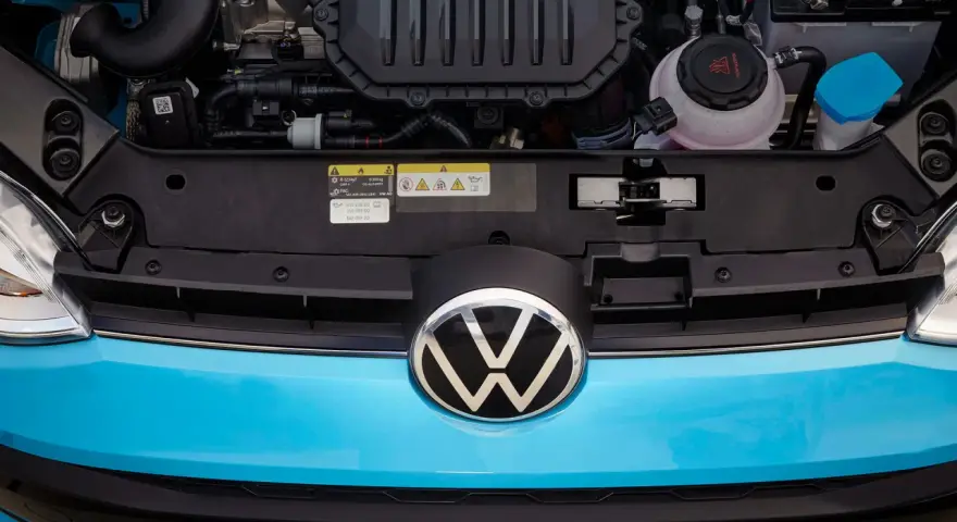 Motorutrymmet på en blå Volkswagen. En etikett visar information om oljespecifikationer, vilket kan vara relevant vid ett volkswagen gasbil problem.