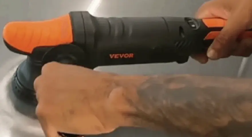 En person använder en polermaskin med borrmaskin för att polera en yta.