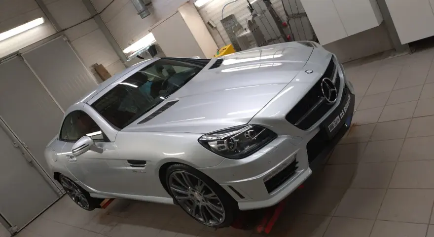 Silver Mercedes-Benz cabriolet i verkstad, redo för en power lock-behandling.