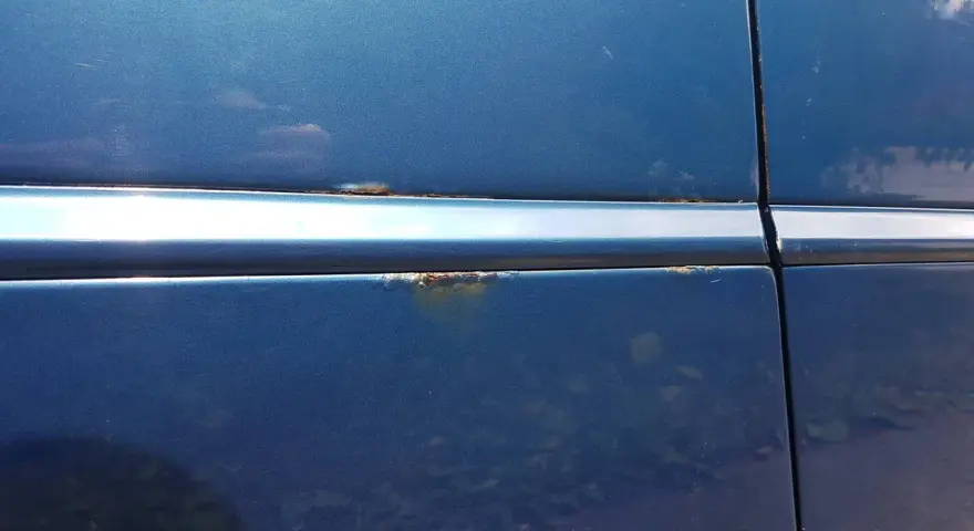 Rostfläckar på blå bil. Dags att lacka om bilen innan det blir värre.
