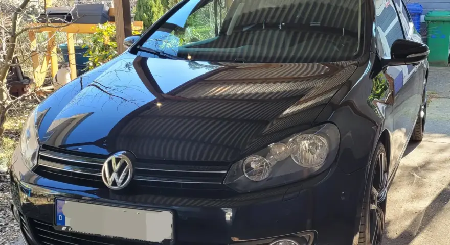 Svart VW Golf med en potentiell vw dsg problem. Bilen står parkerad utomhus under ett skärmtak.