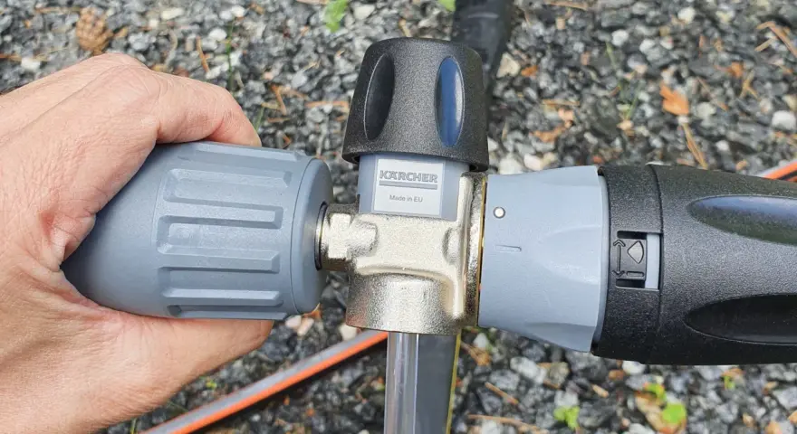 Hand connecting a Kärcher foam lance to a Kärcher K5 pressure washer.