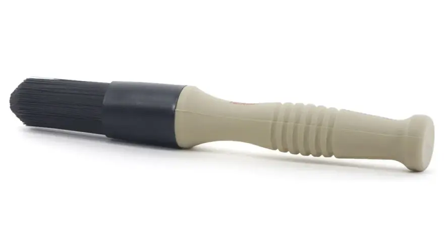 En borste med beige handtag och svart borsthuvud, perfekt för att applicera lahega polermedel för en skinande finish.