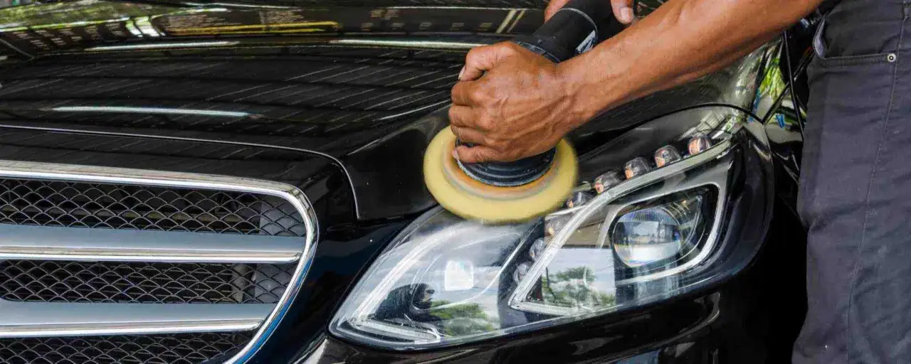 Polering av bilens strålkastare med en polermaskin, ger en glans som en Turtle Wax-behandling.