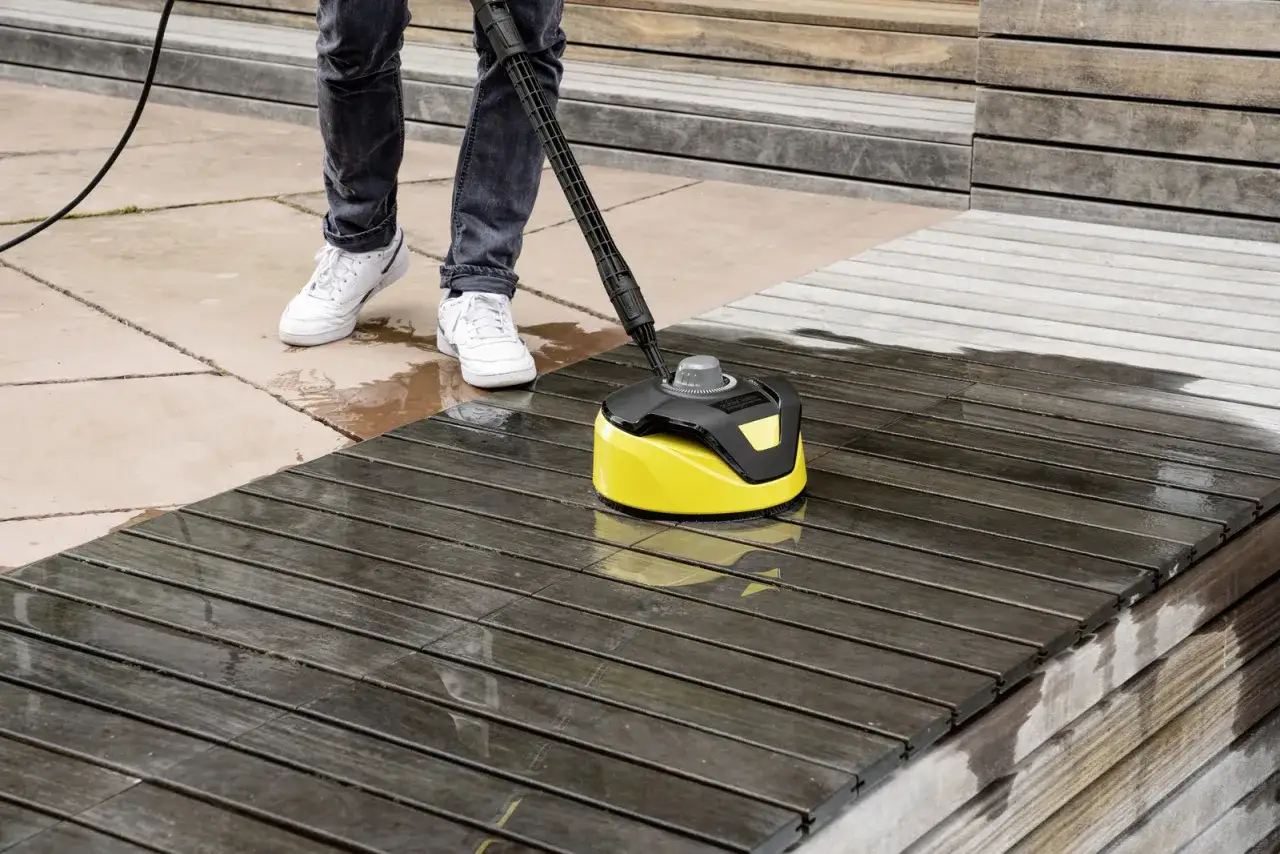 En person använder en Kärcher K4 Power Control för att rengöra en träaltan.