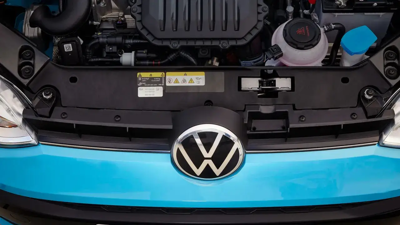 Motorutrymmet p&aring; en bl&aring; Volkswagen. En etikett visar information om olja, vilket kan indikera ett volkswagen gasbil problem.